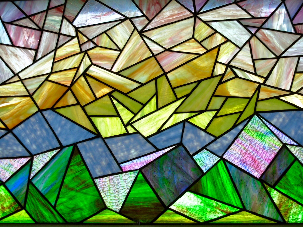 stained glass mosaic piece, giving the impression of a blue mountain scene with a peach to yellow sky