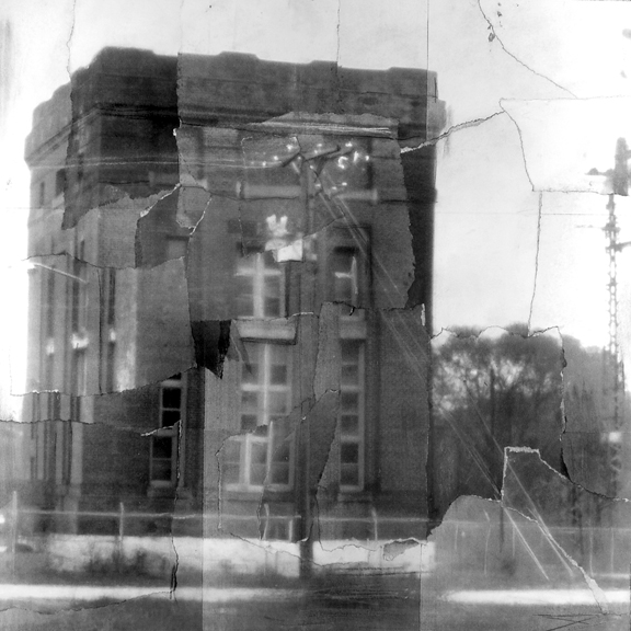 a black and white image of a building with a torn up or fractured effect