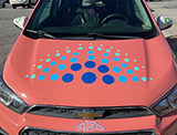 a coral car hood with blue painted bubble decals
