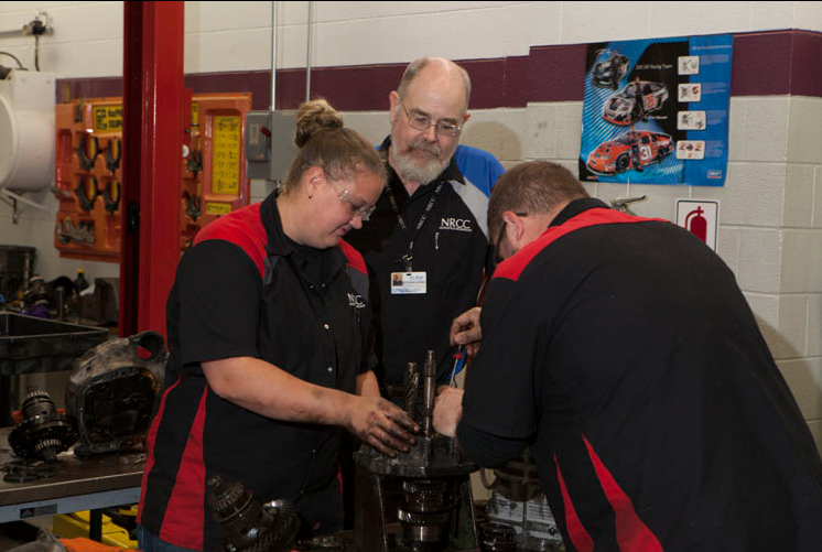 Students and teacher work in auto lab