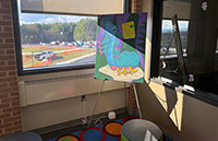 Alice in wonderland art in a corner of the library by a window overlooking parking lot E