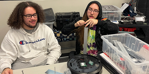 Two people working on a robot together