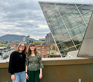 Two students posed with downtown Roanoke in the background behind them.